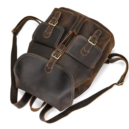 The Vintage Leather Backpack is a chic and timeless accessory made from cowhide leather, accentuated with brass buckles and multiple pockets. It comes with adjustable black straps and a sleek design, making it ideal for both travel essentials and everyday use.