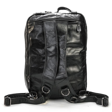 The Leather Travel Backpack Shoulder Bag, crafted from genuine black cowhide leather, boasts a sleek and glossy finish. This luxury accessory is equipped with sturdy adjustable shoulder straps, multiple zippered compartments, and a convenient top handle. The bag is displayed with the straps and back side facing forward.