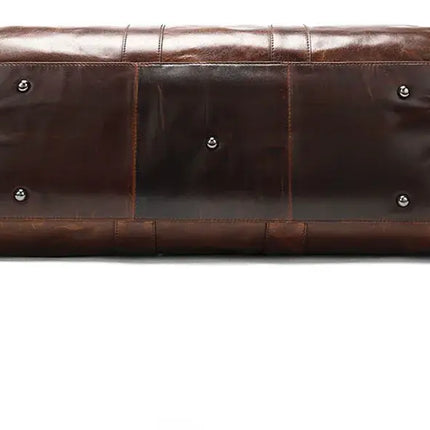 The image displays the bottom view of the Unisex Genuine Leather Travel Duffle Bag. The base showcases a patchwork design complemented by five small metallic studs arranged in a square pattern, with one stud positioned at the center for added support. The genuine leather has a slightly glossy finish.