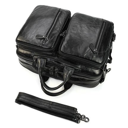 Introducing the Leather Travel Backpack Shoulder Bag, crafted from genuine cowhide leather. This black luxury accessory features multiple zippered compartments and sturdy carrying handles, along with a detachable shoulder strap that is displayed separately in front of it. The backpack boasts a sleek, polished appearance perfect for discerning travelers.