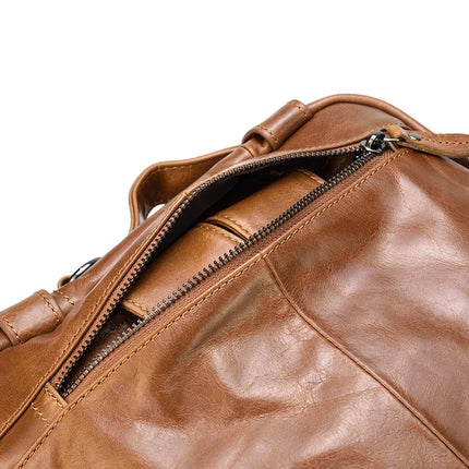 Close-up of a brown Leather Travel Backpack Shoulder Bag, emphasizing an open zipper pocket that offers a peek at the bag's contents. The genuine cowhide leather exhibits a slightly worn, rustic look, and the zipper is detailed with silver teeth and a matching pull tab.