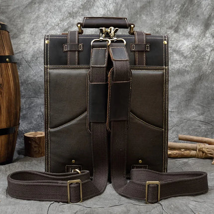 A stylish, dark brown Leather Business Travel Briefcase Backpack with matching brown straps is shown against a gray textured background. The backpack features gold metal hardware, detailed stitching, and two front pockets. Made from genuine cowhide leather, it offers a lifetime warranty. A wooden barrel is partially visible on the left side.