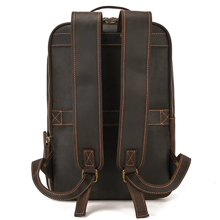 The Vintage Leather Daypack is a dark brown backpack made from genuine cowhide leather, featuring two adjustable shoulder straps and contrasting stitching. It has a carrying handle at the top and boasts a sleek, rectangular shape, making it an ideal unisex accessory.