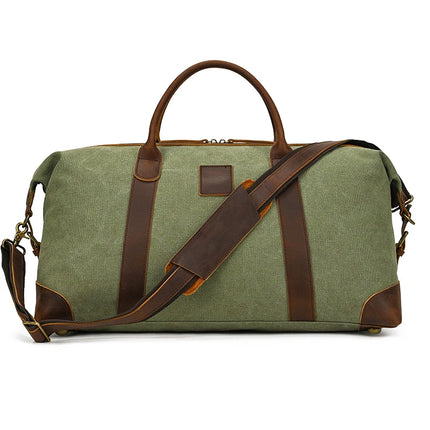 The Canvas & Leather Travel Duffle is a vintage green accessory featuring genuine leather accents, an adjustable shoulder strap, two sturdy top handles, leather corner protectors, and a prominent zipper closure for all your travel needs.