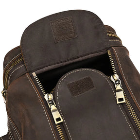 A close-up image of an open Luggage 24 Leather Travel Bag with visible zippers and stitching details. The top flap is lifted, revealing the zipper teeth and pull tabs. The material appears sturdy, with a rustic and rugged design, perfectly embodying the essence of a genuine leather bag.