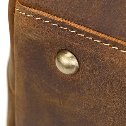 Close-up of the Genuine Leather Women's Tote Bag – Large Capacity Business Handbag, featuring a brass rivet and visible stitching. Its slightly worn texture enhances its rustic, vintage style. Despite its compact appearance, it boasts a spacious interior ideal for daily essentials.
