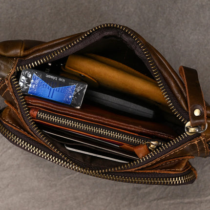 A top view of the genuine Leather Belt Bag showcases its contents. Inside this stylish accessory, you can see a pack of tissues, a brown notebook, a matching wallet, a black smartphone, and a pen alongside what appears to be a folded paper or cardboard item. A real treat for any fashion expert!