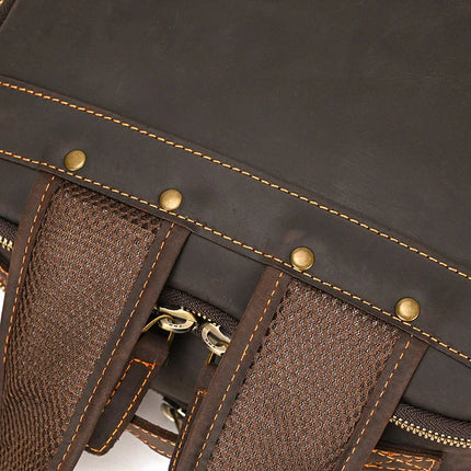 Close-up view of the Vintage Leather Daypack showcasing its detailed stitching, brass rivets, and brown mesh straps. A zipper is partially visible, highlighting the blend of materials and craftsmanship. This genuine cowhide leather unisex backpack epitomizes timeless style and durability.