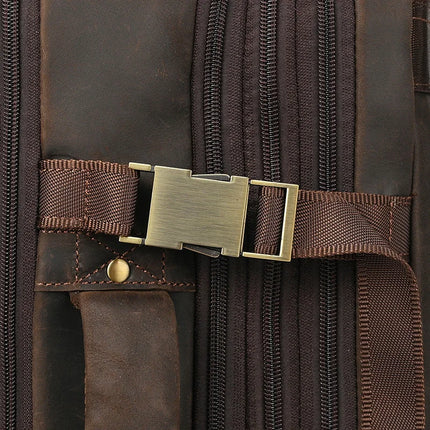 Close-up of the Vintage Leather Travel Backpack, crafted from genuine brown leather. It features a metal buckle, several zippers, and a stitched handle. The brass-colored hardware complements the dark leather material, which boasts intricate stitching and sturdy rivets.