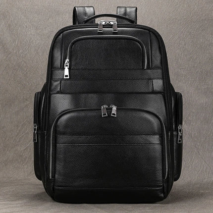 The Black Leather Travel Backpack is showcased against a plain gray background, featuring multiple zippered compartments. Its sleek, minimalist design includes silver zipper accents, a spacious interior, and padded shoulder straps for enhanced comfort.