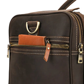 Close-up of the Luggage 24 Leather Travel Bag with a brass zipper. The zipper is partially open, revealing an orange-brown wallet. This genuine leather bag features contrasting white stitching and a brass D-ring at the top, perfect for your next adventure.