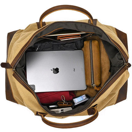 A top view of the open Canvas & Leather Travel Duffle in beige and brown, containing a laptop, brown wallet, black jacket, beige pouch, red fabric item, sunglasses, keys, and a small tube.