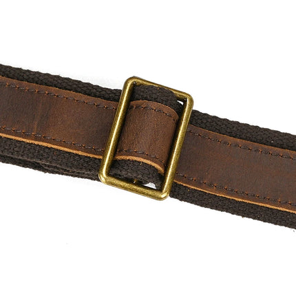 A close-up of a genuine leather brown belt with a brass rectangular buckle, featuring a textured design and darker border, adds vintage charm with its slightly worn look against a plain white background. Product: Canvas & Leather Travel Duffle.