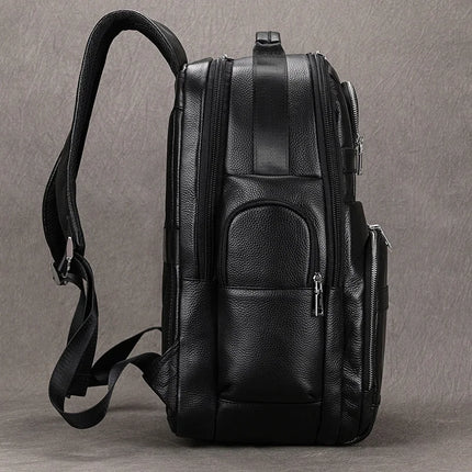 The Black Leather Travel Backpack is displayed from a side angle against a plain, textured backdrop. It showcases multiple zippered compartments, adjustable shoulder straps, and a roomy interior. The premium leather construction features an elegant textured finish.