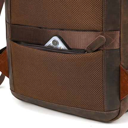 Here's a close-up of the Vintage Leather Travel Backpack in brown genuine leather. It features a mesh pocket on the side where a smartphone is partially visible, highlighting the practicality and timeless appeal of this men's softback design.