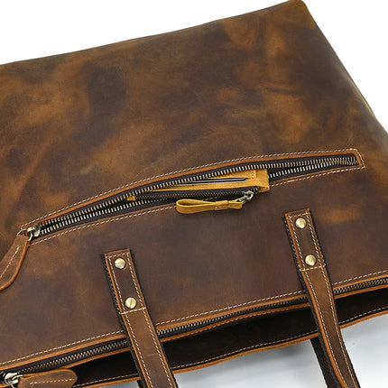 Close-up of the Genuine Leather Women's Tote Bag – Large Capacity Business Handbag, showcasing its visible stitching and metal rivets. The bag includes a zipper pocket on the front and comes with two handles. Its worn, textured appearance gives it a vintage style, while its spacious interior ensures practicality for everyday use.