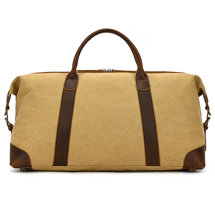 Tan Canvas & Leather Travel Duffle featuring genuine leather handles, metal rivets, zipper closure on top, and a detachable shoulder strap. Its design is vintage-inspired yet minimalist and versatile.