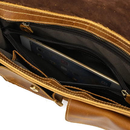 The Leather Business Travel Shoulder Bag showcases a tablet inside its inner zippered compartment. Crafted from genuine cowhide leather in an open brown design, this bag also features a buttoned outer pocket and another top-view compartment, accentuated with high-quality alloy hardware.