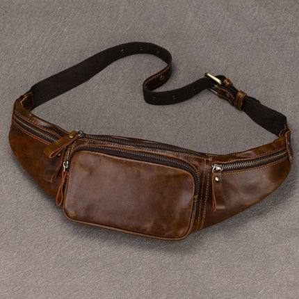 A genuine cowhide Leather Belt Bag with three zippered compartments. The bag features a smaller front pocket and two larger side pockets, each with its own zipper. The adjustable black nylon strap has a buckle closure. Fashion experts will appreciate its durability and style, laid flat on a textured gray surface.