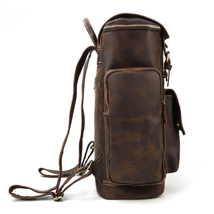 Side view of the Vintage Leather Travel Backpack showcasing multiple compartments, zippers, and adjustable shoulder straps. This brown leather bag features a rugged, slightly worn finish made from genuine cowhide leather and includes a handy laptop compartment for your tech essentials.